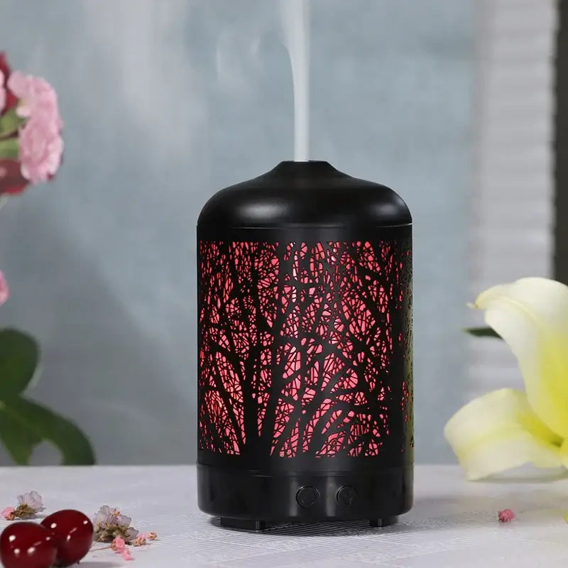 Black metal essential oil diffuser with glowing red tree branch design cutouts