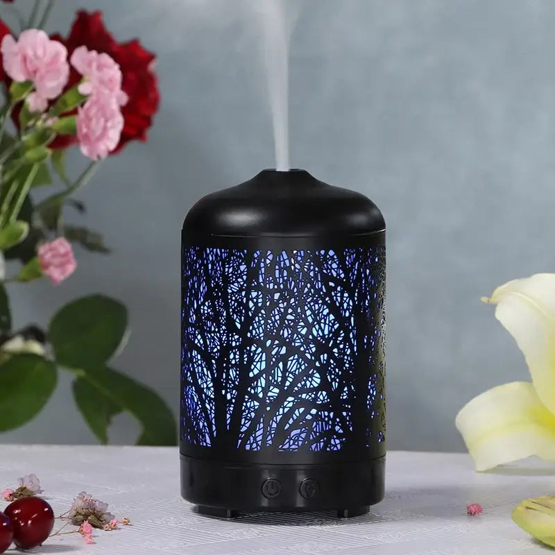 Black cylindrical essential oil diffuser with illuminated Sacred Tree design for ultrasonic aromatherapy