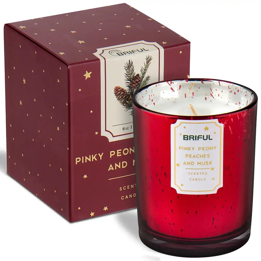 Red glass scented soy candle in decorative burgundy gift box with gold stars and pine cones