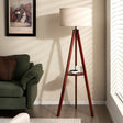 Tripod floor lamp with a white shade and built-in circular shelf for stylish lighting