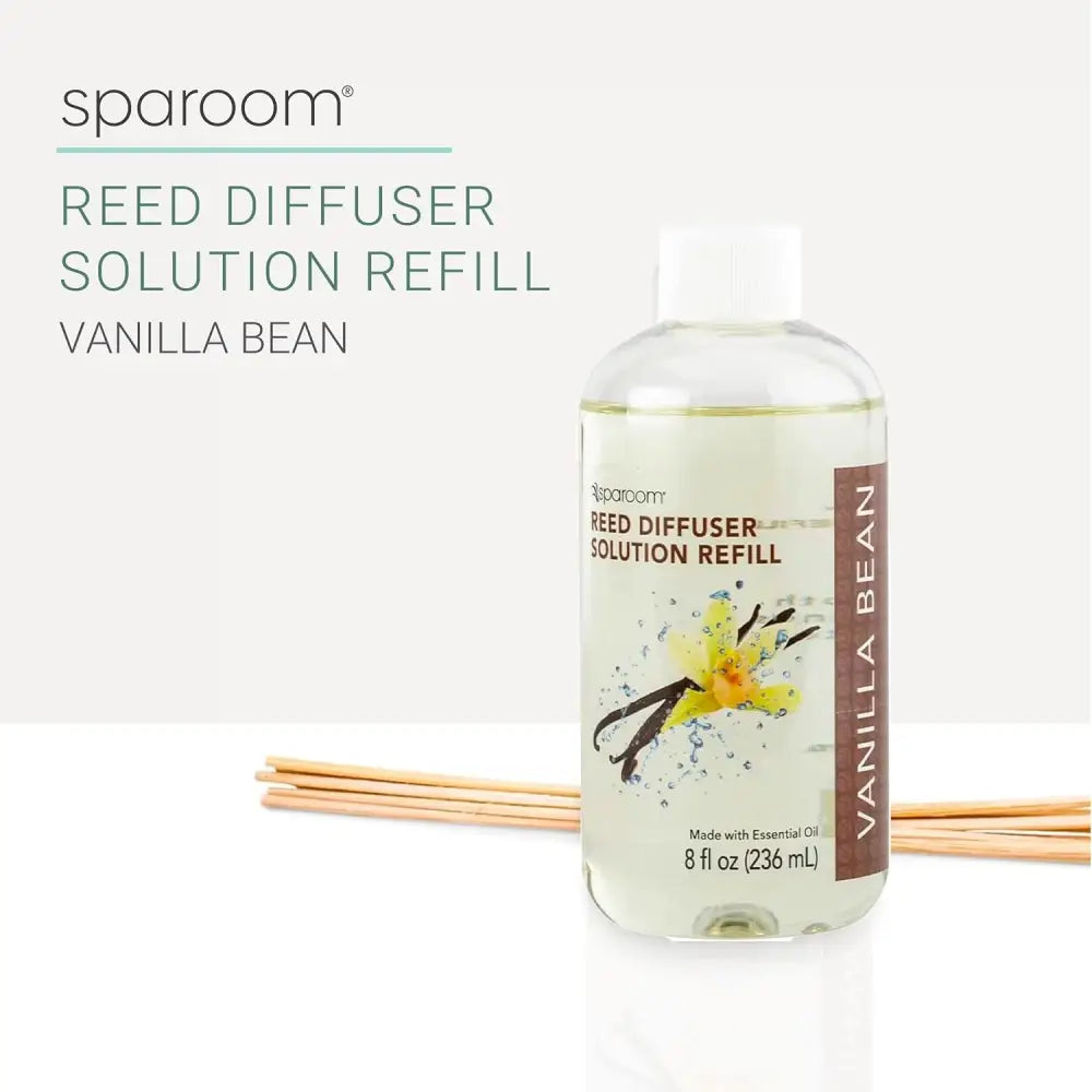 Clear bottle of Vanilla Bean Oil Reed Diffuser refill with wooden reeds beside it