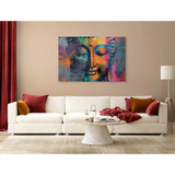 White sectional sofa with red and orange pillows beside Buddha Head Canvas art