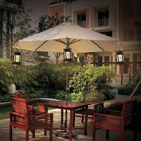 Cream-colored patio umbrella with lanterns over red furniture and Waterproof LED Solar lights